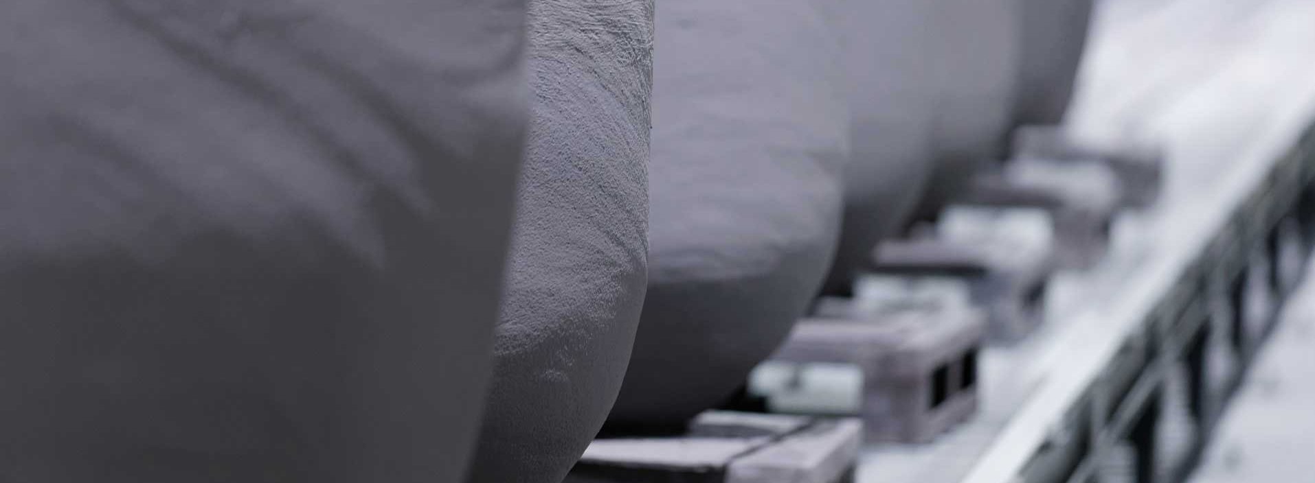 Close-up of FOSECO crucibles lined up in a storage facility – showcasing durable refractory solutions for efficient metal melting in non-ferrous foundry applications.