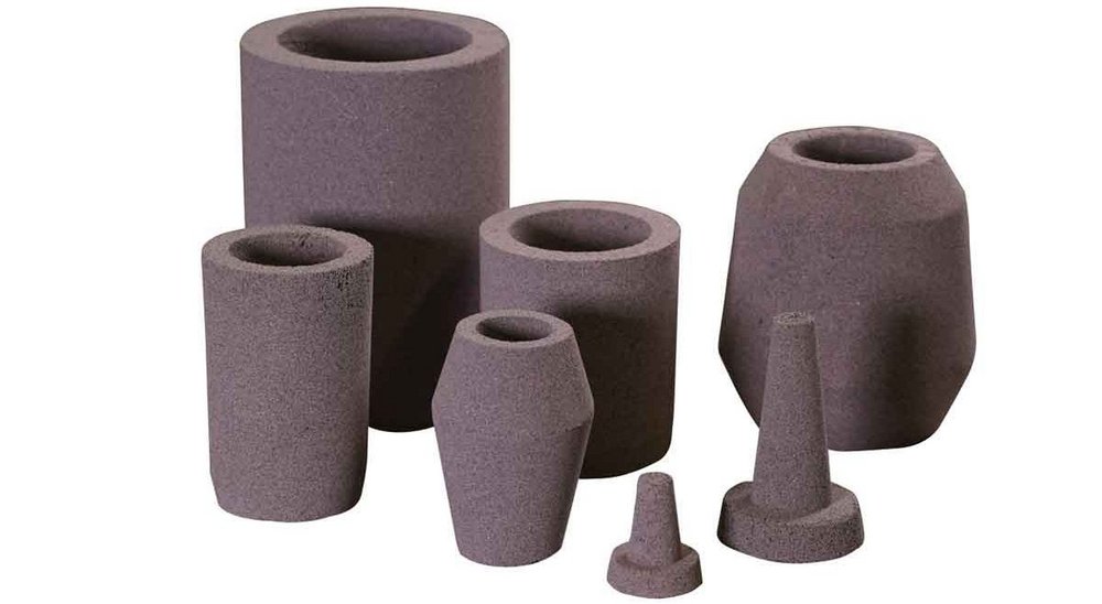 A selection of FEEDEX NF1 risers in various sizes for aluminum foundry applications, with a focus on their unique shapes and textures