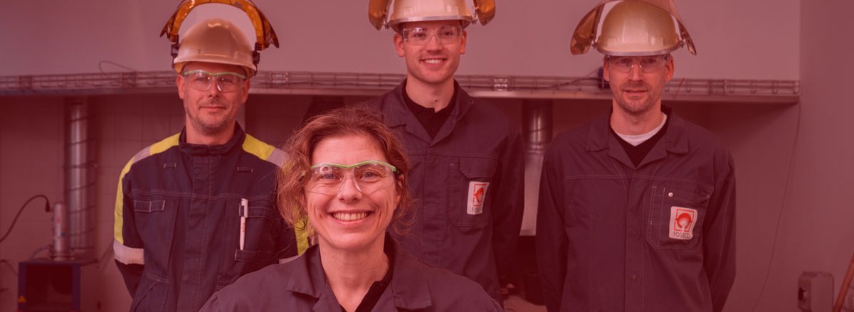 Group of Foseco R&D people in laboratory coats, some of them are wearing heat protection helmets