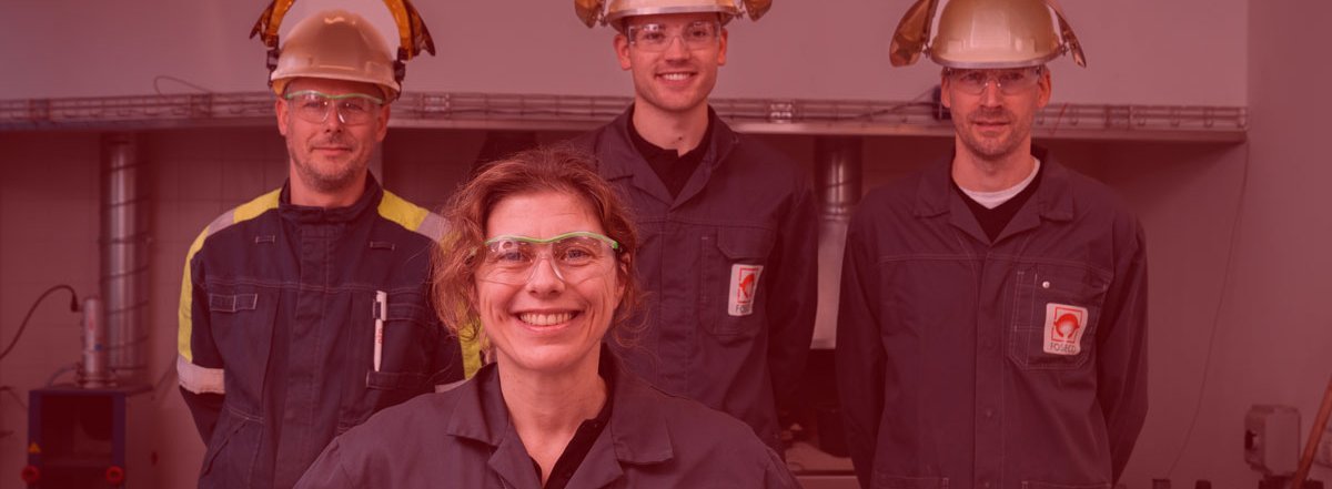 Group of Foseco R&D people in laboratory coats, some of them are wearing heat protection helmets