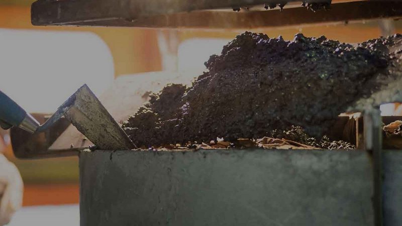 Close-up of a foundry process with molten material being poured into a casting form, highlighting the precision and heat involved in metalworking.