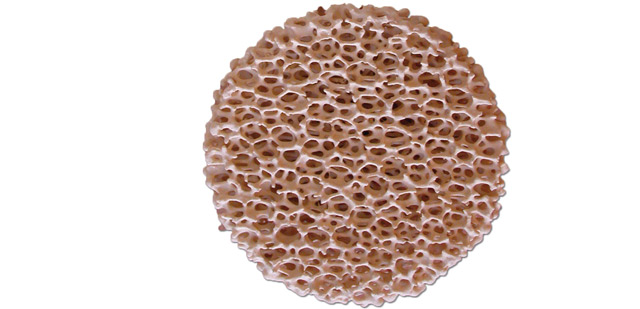 Foseco's beige-colored STELEX Zr ceramic foam filter with a honeycomb structure for metal casting applications, isolated on a white background