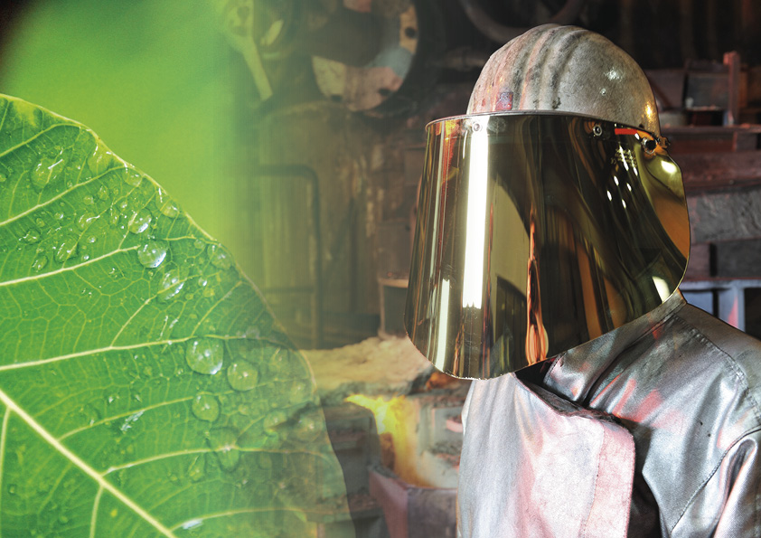 Close-up of a foundry worker wearing a reflective face shield and protective clothing, juxtaposed with a large green leaf with water droplets, symbolizing environmentally conscious manufacturing processes.